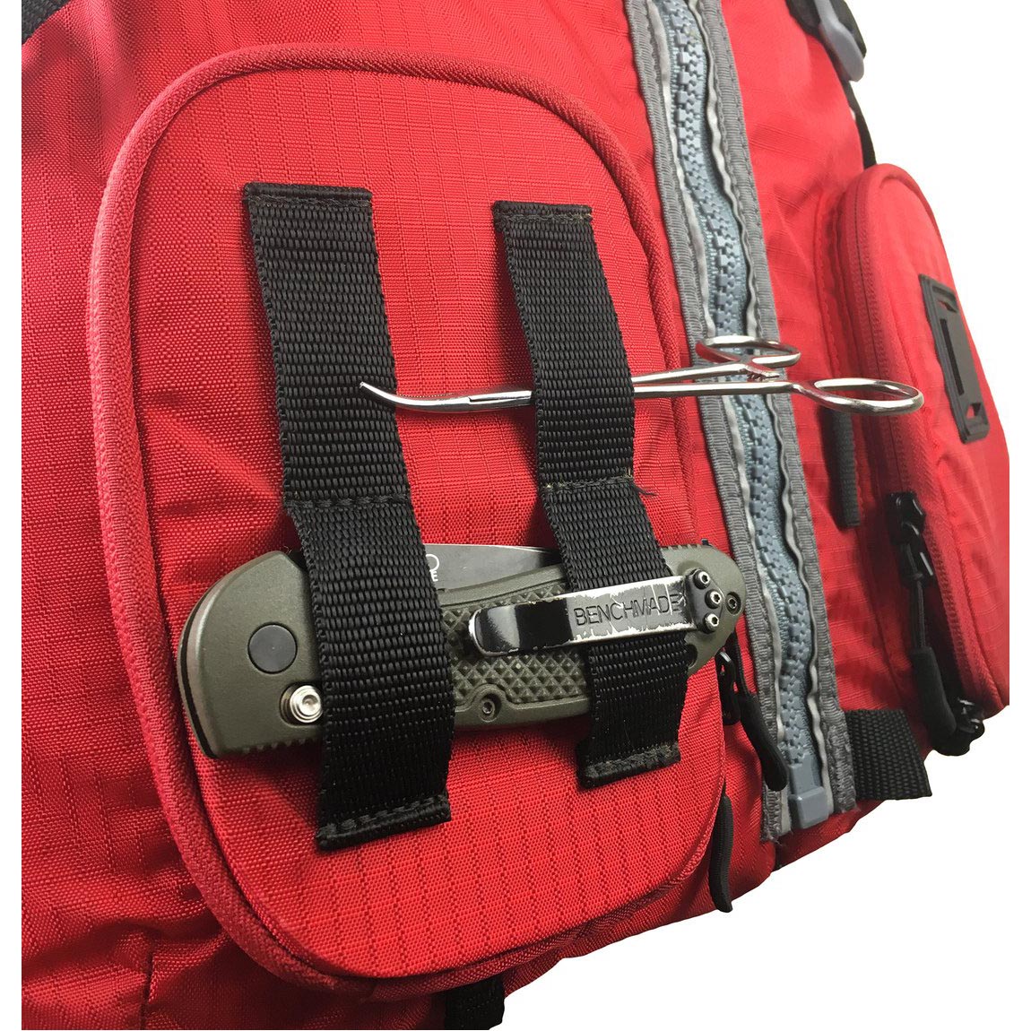 Close-up of Stohlquist red kayak life jacket with knife and fishing pliers attached.